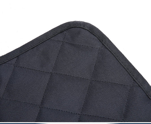 Close-up of a textured black car seat cover with a diamond pattern.