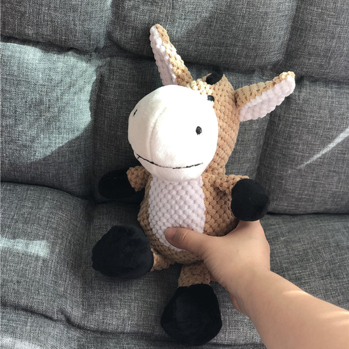 Hand holding a small unicorn plush toy on a textured gray surface