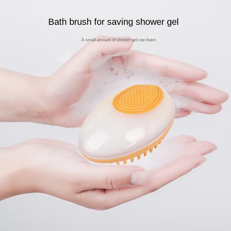 Bath brush with orange bristle head and clear handle held in hands with foamy shower gel.