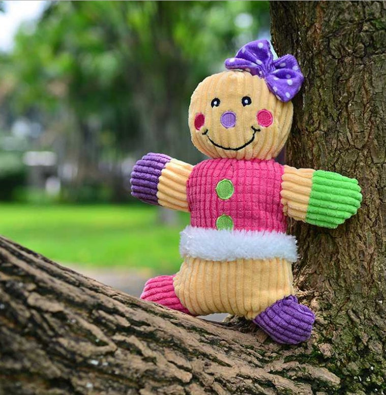 Toy figure with a colorful outfit sitting on a tree branch outdoors