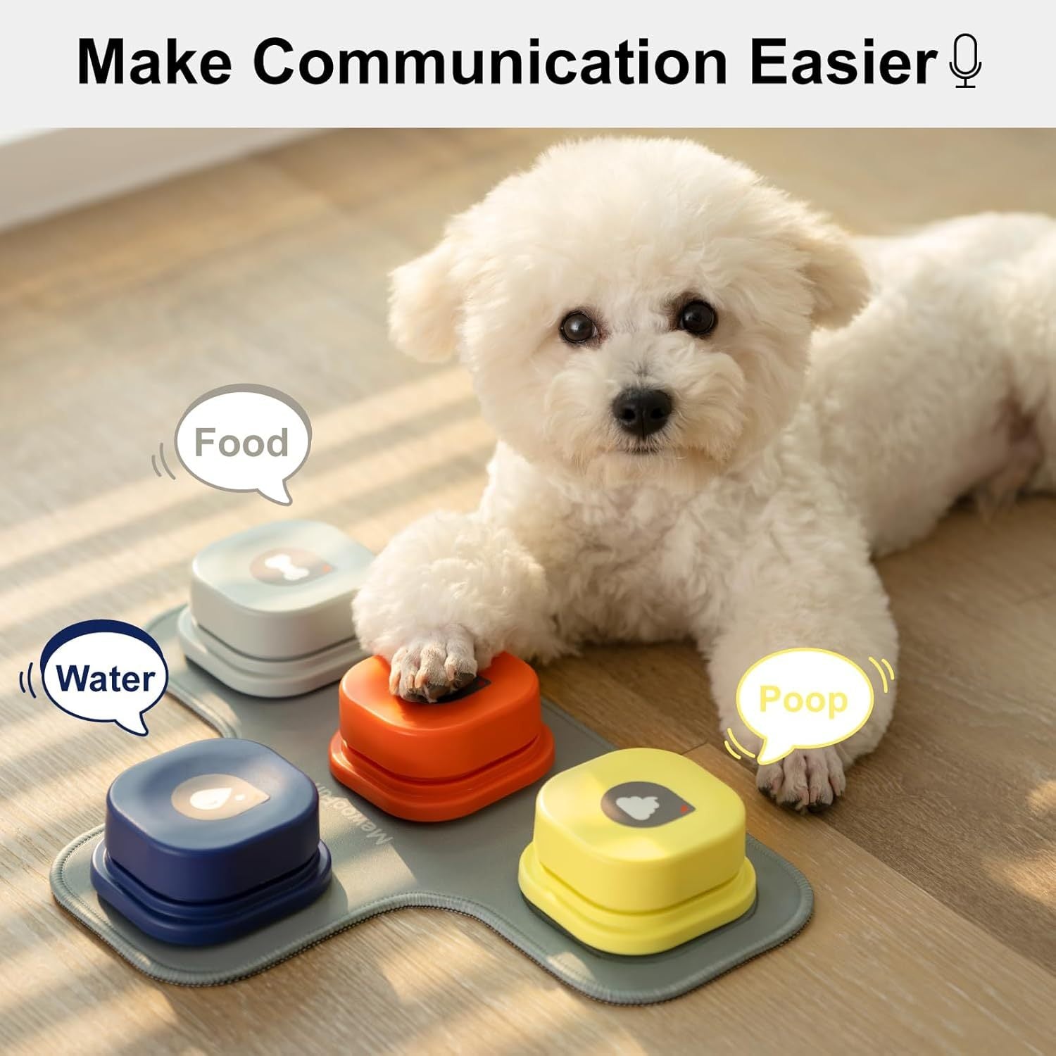 White dog interacting with a set of colorful communication devices