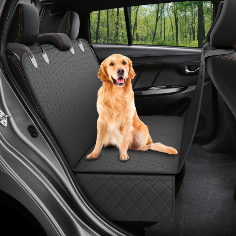 Dog sitting on a black car seat cover in a vehicle
