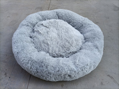 Fluffy gray pet bed on a concrete surface