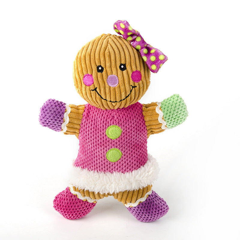 Knitted gingerbread girl toy with a pink dress and green buttons on a white background