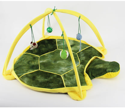 Tortoise-shaped play mat with hanging toys on a white background