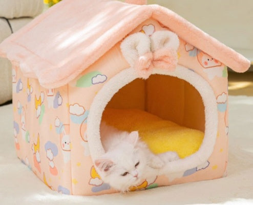 Pink pet house with cartoon patterns and a white cat inside
