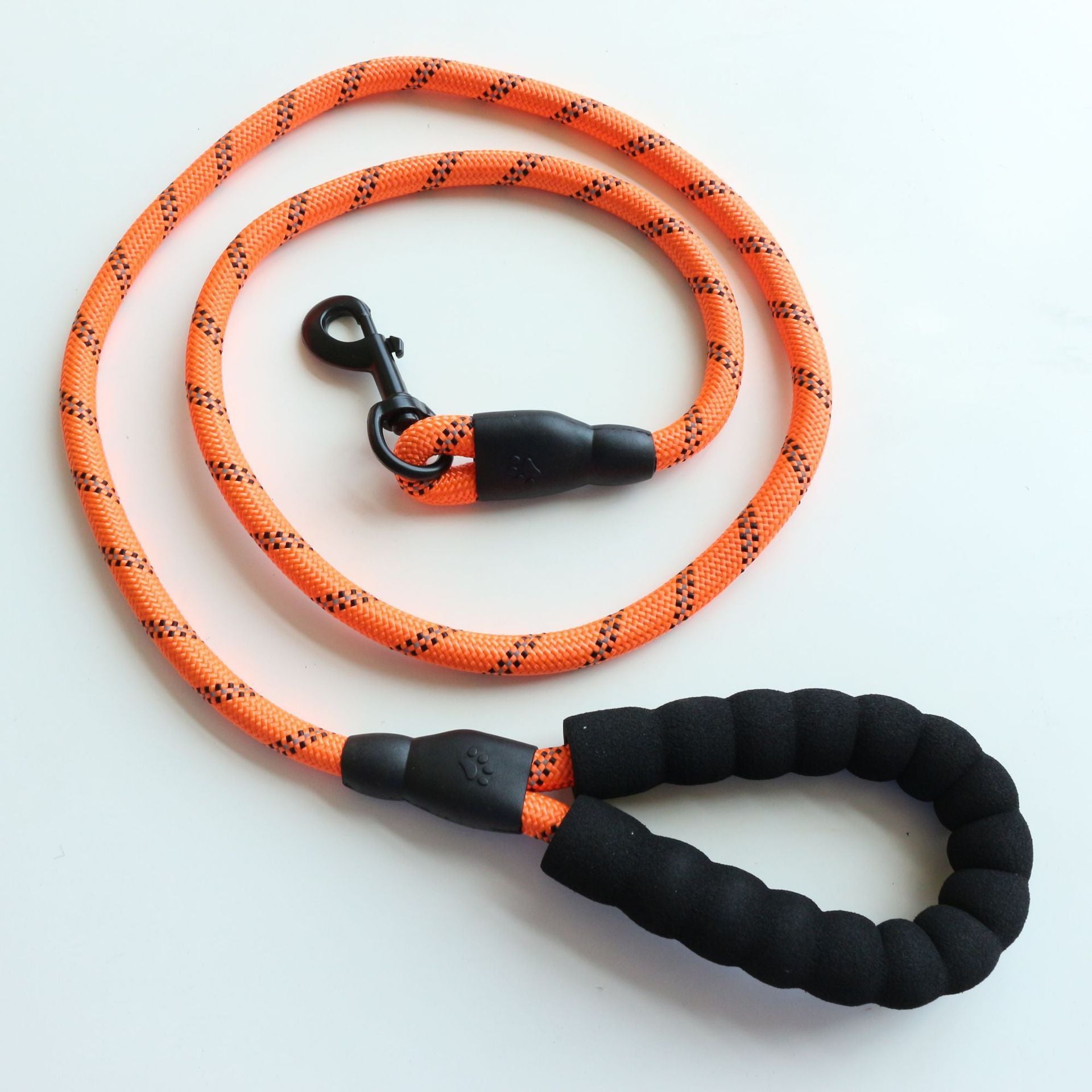 Orange and black dog leash with a black handle on a white background