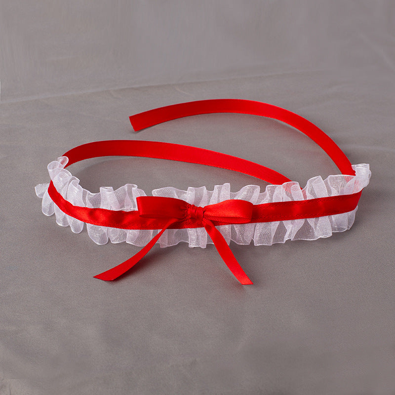 Red headband with a white lace bow on a gray background