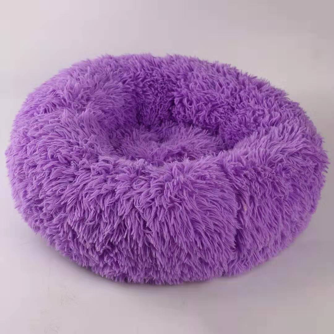 Purple fluffy pet bed on a white background